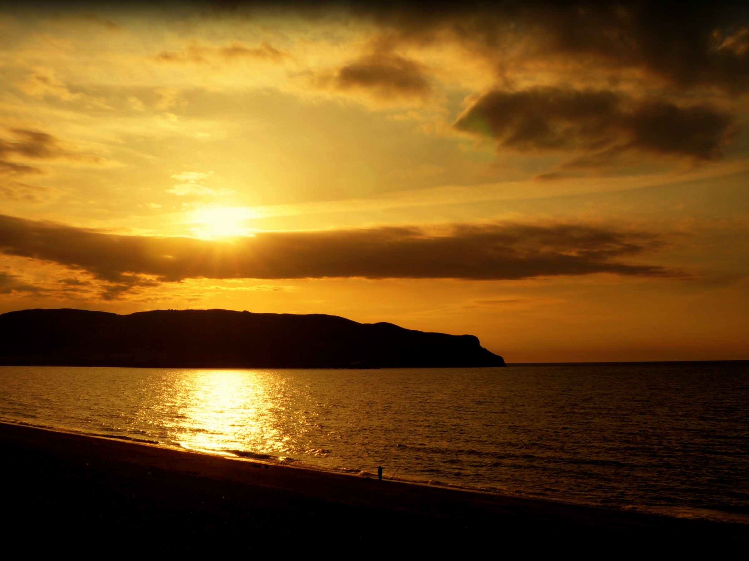 Sunset over Llandudno bay with the Great Orme headland in silhouette